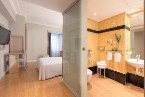 a bathroom with a bed and a sink at Hotel San Sebastián Orly, Affiliated by Meliá in Donostia-San Sebastián