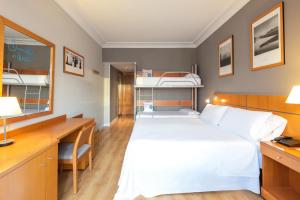 a bedroom with a bed and a desk and bunk beds at Hotel San Sebastián Orly, Affiliated by Meliá in Donostia-San Sebastián