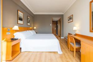 a hotel room with a white bed and a desk at Hotel San Sebastián Orly, Affiliated by Meliá in Donostia-San Sebastián