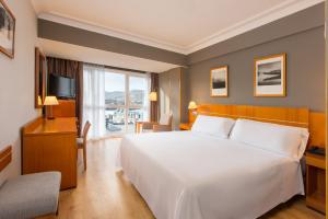 a hotel room with a large bed and a television at Hotel San Sebastián Orly, Affiliated by Meliá in Donostia-San Sebastián