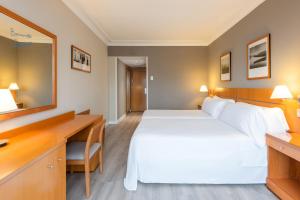 a hotel room with a bed and a desk at Hotel San Sebastián Orly, Affiliated by Meliá in Donostia-San Sebastián