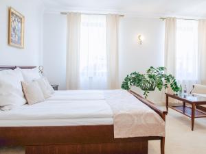 a bedroom with a large bed and a table at Hotel Koloseum in Turek