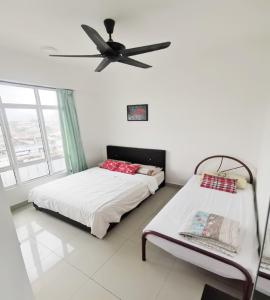 a bedroom with two beds and a ceiling fan at Ipoh City Center Homestay in Ipoh