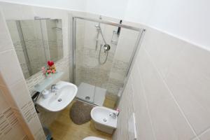 a white bathroom with a shower and a sink at B&B Lidiya in Bologna
