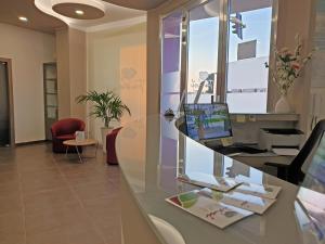 una oficina con un escritorio con un ordenador portátil en un mostrador en Travini Hotel Residence, en Marsala