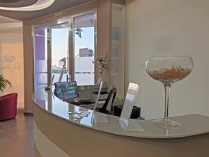 un bureau avec un verre de vin et un bureau dans l'établissement Travini Hotel Residence, à Marsala