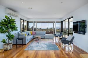a living room with a couch and chairs and windows at The Views: Entertainers' deck and bay views in Sorrento