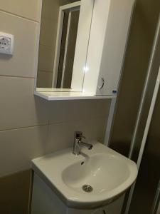 y baño con lavabo blanco y espejo. en apartment jankovic en Zlatibor