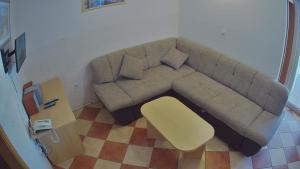 a brown couch in a living room with a yellow stool at Apartments Pag-Travel in Novalja