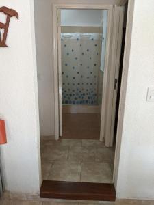 un couloir avec une porte menant à une salle de bains. dans l'établissement Calle 3 1526, à Santa Teresita