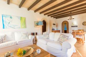 a living room with white couches and a table at Villa Totxa in Pollença