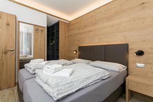a bedroom with two beds and a wooden wall at VillaGiardino - Lake in Molveno