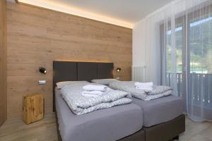 a bedroom with two beds with towels on them at VillaGiardino - Lake in Molveno