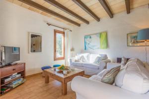 a living room with two white couches and a tv at Villa Totxa in Pollença