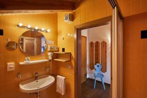 a bathroom with a sink and a mirror at Hotel Pensione Veneranda in Corvara in Badia