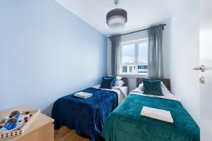 1 dormitorio con 2 camas y ventana en Warszawa Zachodnia Station Serviced Apartments, en Varsovia