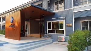 una casa con una puerta de madera y escaleras al aire libre en AT TP HOTEL, en Phetchabun