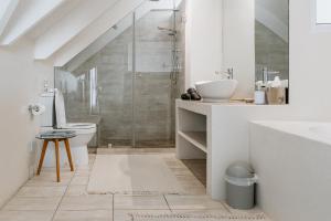 a bathroom with a shower and a toilet and a sink at De Linden Boutique Guest House in Paternoster