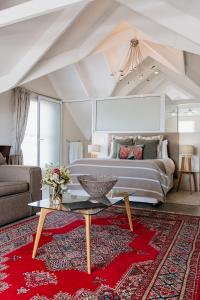 a bedroom with a bed and a red rug at De Linden Boutique Guest House in Paternoster