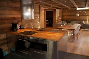- une cuisine avec un comptoir en bois et une table dans l'établissement Chalet Bella Alpina, à Bonneval-sur-Arc
