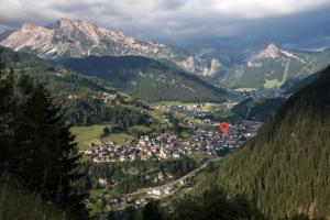 a town in the mountains with a red kite in the air at La Tambra - Residence - Central with Restaurant in Santa Cristina Gherdëina +99 photos