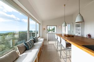 un soggiorno con un lungo divano e una grande finestra di Sea View Cascais Design Villa a Alcabideche