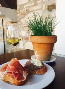 um prato de comida e um copo de vinho numa mesa em Agriturismo Mulino Delle Tolle em Bagnário Arsa