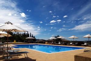 einen Pool mit Stühlen und Sonnenschirmen in der Unterkunft Locanda San Verolo in Costermano sul Garda
