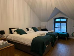 Un dormitorio con dos camas con mantas verdes. en Folwark Wąsowo, en Wąsowo