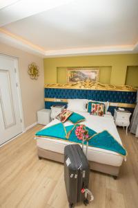 a bedroom with a bed with a suitcase in it at Atlantis Royal Hotel in Istanbul