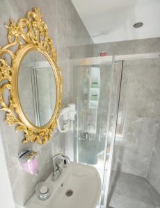 a bathroom with a mirror and a sink and a shower at Atlantis Royal Hotel in Istanbul