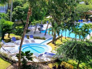 una piscina al aire libre con sillas y un complejo en Comfortable Apartment in Caribbean Paradise, en Sosúa