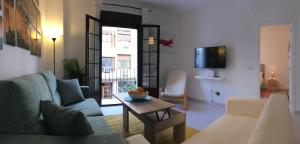 a living room with a couch and a table at Apartamentos Baiti Ronda in Ronda