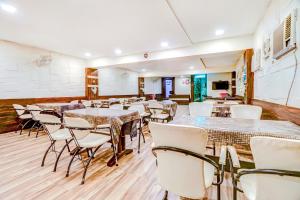 an empty room with tables and chairs in it at FabHotel Anandam in Raipur