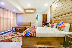 1 dormitorio con cama, silla y escritorio en FabHotel Anandam, en Raipur