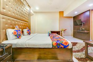 Habitación de hotel con cama y TV en FabHotel Anandam en Raipur