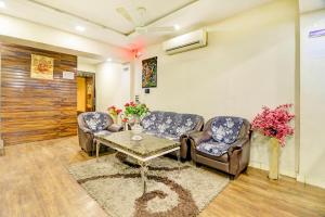 a living room with two chairs and a table at FabHotel Anandam in Raipur