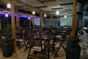 a restaurant with wooden tables and chairs and lights at Tropics Hotel - Ultra All Inclusive in Sveti Vlas