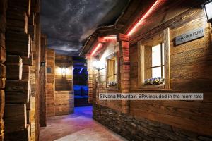 una habitación con una pared de piedra y una ventana y una habitación con un edificio en Silvana Mountain Hotel, en Zermatt