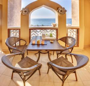 een eetkamer met een tafel en stoelen en een raam bij Luxury Apartments at Balqis Residence in Dubai