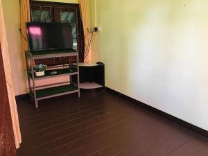 um quarto com uma televisão de ecrã plano numa prateleira em Green Garden House em Ao Nam Mao