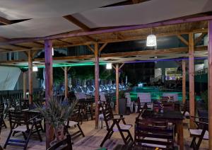 a restaurant with tables and chairs and a pool at Tropics Hotel - Ultra All Inclusive in Sveti Vlas