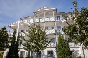 ein Apartmenthaus mit Balkonen und Bäumen in der Unterkunft Villa Linde in Göhren