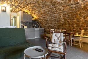 a kitchen with a table and chairs and a stone wall at Loft in the wall in Acre
