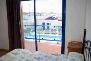 a bedroom with a balcony with a view of a pool at TAO El Cotillo - VV in El Cotillo