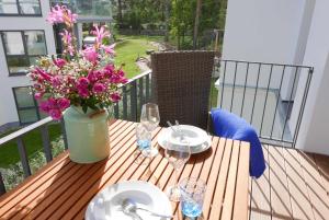 a wooden table with a vase of flowers on a balcony at Baabe Villen Ensemble FeWo 30 Stra in Baabe