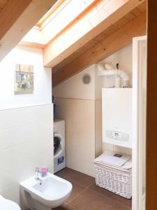 uma casa de banho com um lavatório e uma máquina de lavar roupa em Homely Cortina Ready Experience em San Vito di Cadore