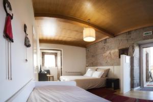 a bedroom with two beds and a stone wall at Casa da Feira in Lobios +39 photos