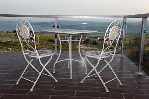 un tavolo e due sedie seduti su un patio di A Window to Kinneret a Safed