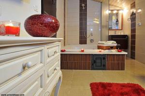 a bathroom with a tub and a large vase on a counter at A Window to Kinneret in Safed